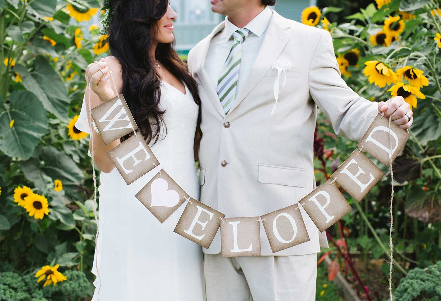 Couple holding "We Eloped" banner